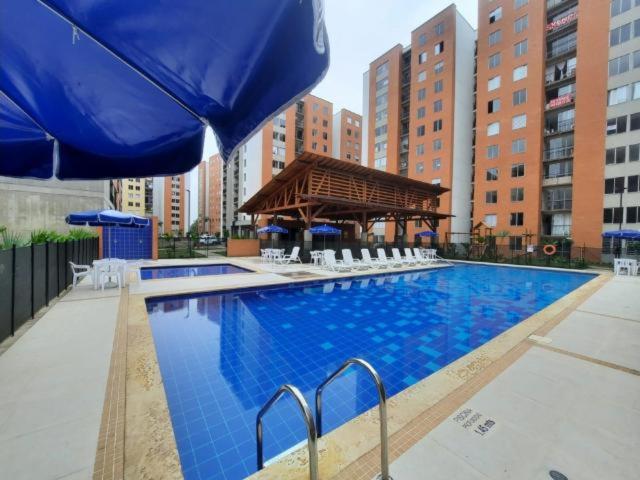 卡利Beautiful Apartment en Cali Colombia的一座拥有建筑的城市里的大型蓝色游泳池