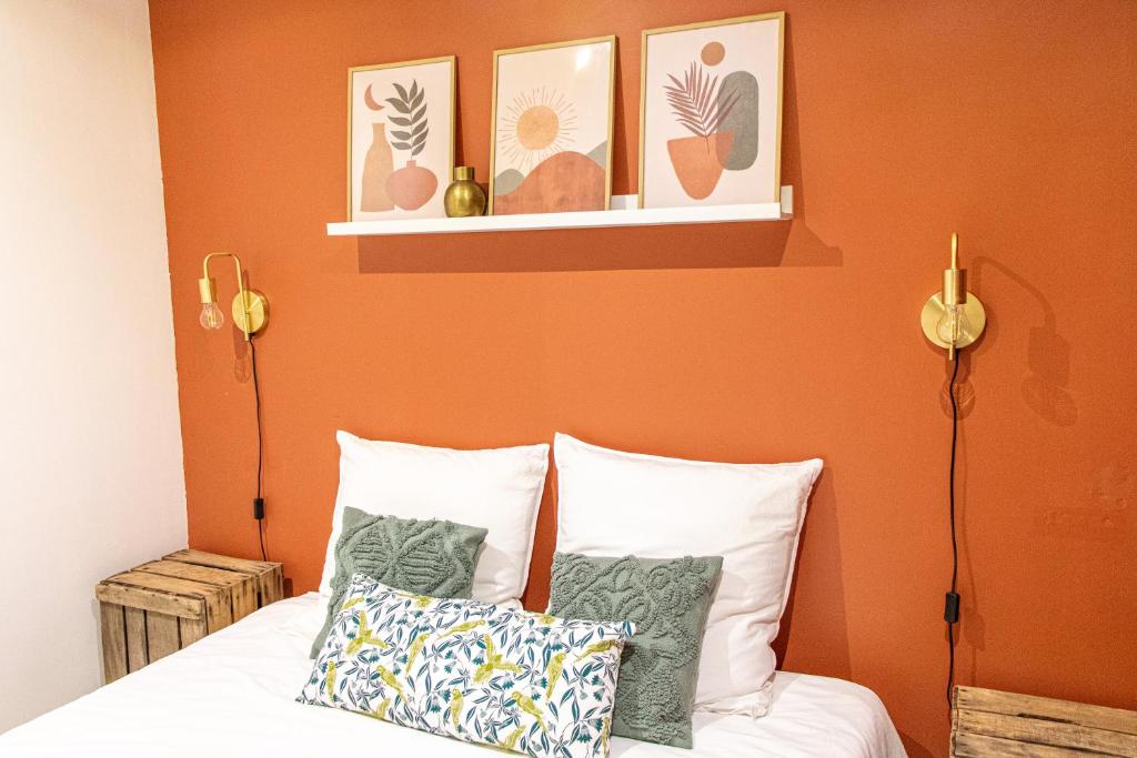 尼姆Nîmes Centre - A 5 minutes des Arènes的一间卧室拥有橙色的墙壁,配有一张带枕头的床。