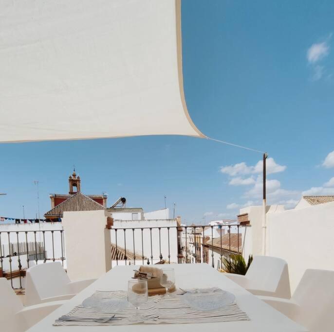 塞维利亚Antigua Casa Hermandad的阳台上配有白色桌子和白色椅子