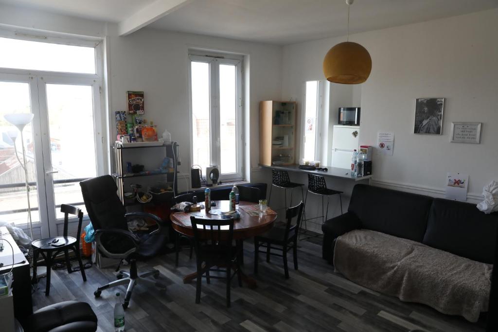 里尔Appartement spacieux Lille的客厅配有桌子和沙发