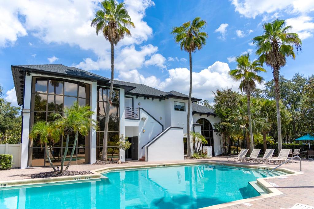 奥兰多Legacy Vacation Resorts - Disney and Lake Buena Vista的棕榈树屋前的游泳池