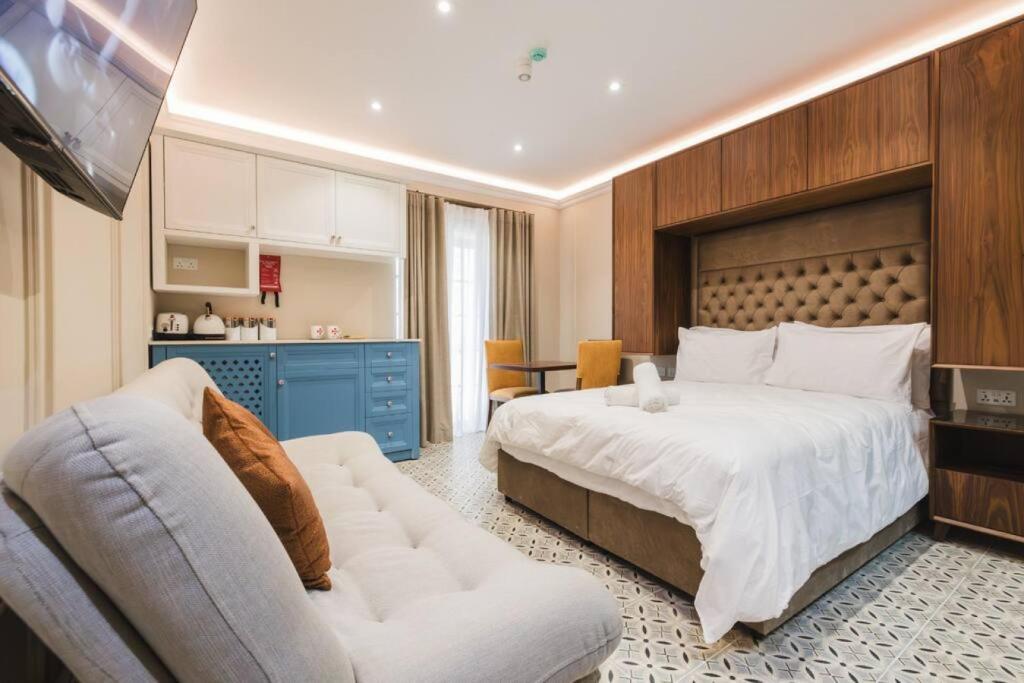 ŻebbuġZebbuga Deluxe Balcony Suite Apartment 4的一间卧室配有一张大床和一张沙发