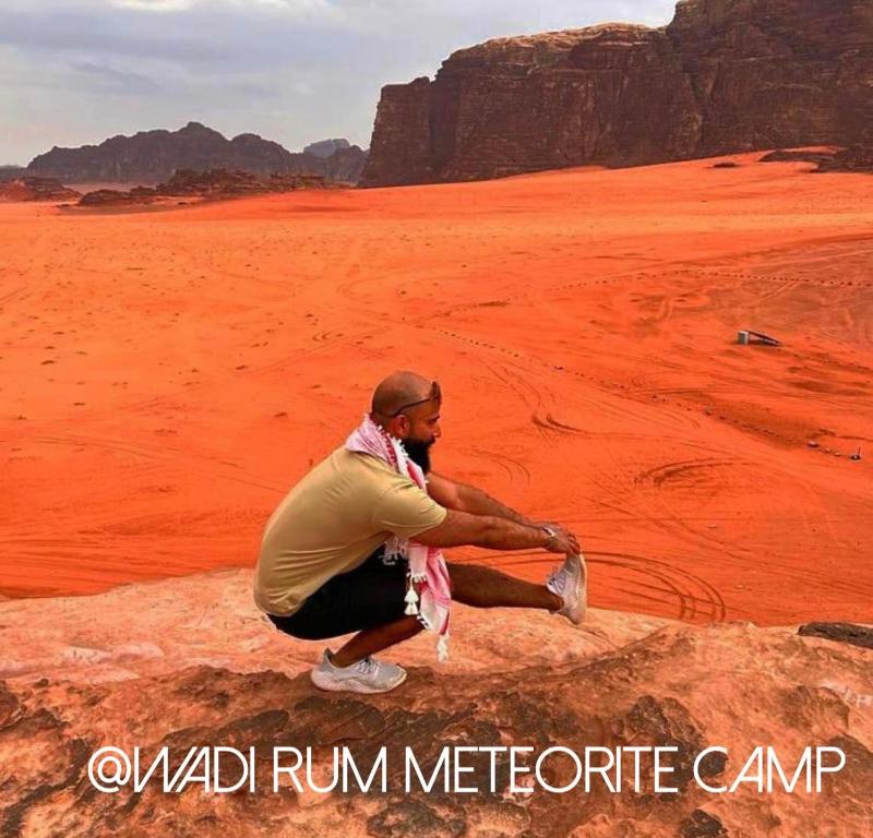 瓦迪拉姆Wadi Rum Meteor camp的坐在沙漠岩石上的人