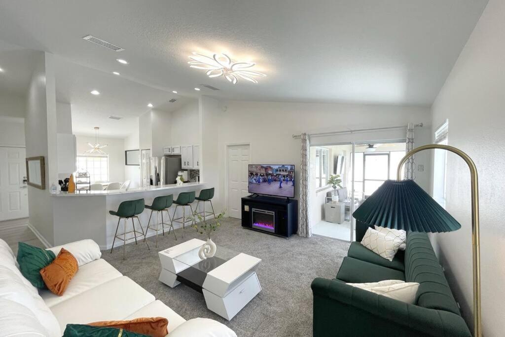 基西米Luxury Modern Pool House close to theme parks.的一间带绿色沙发的客厅和一间厨房