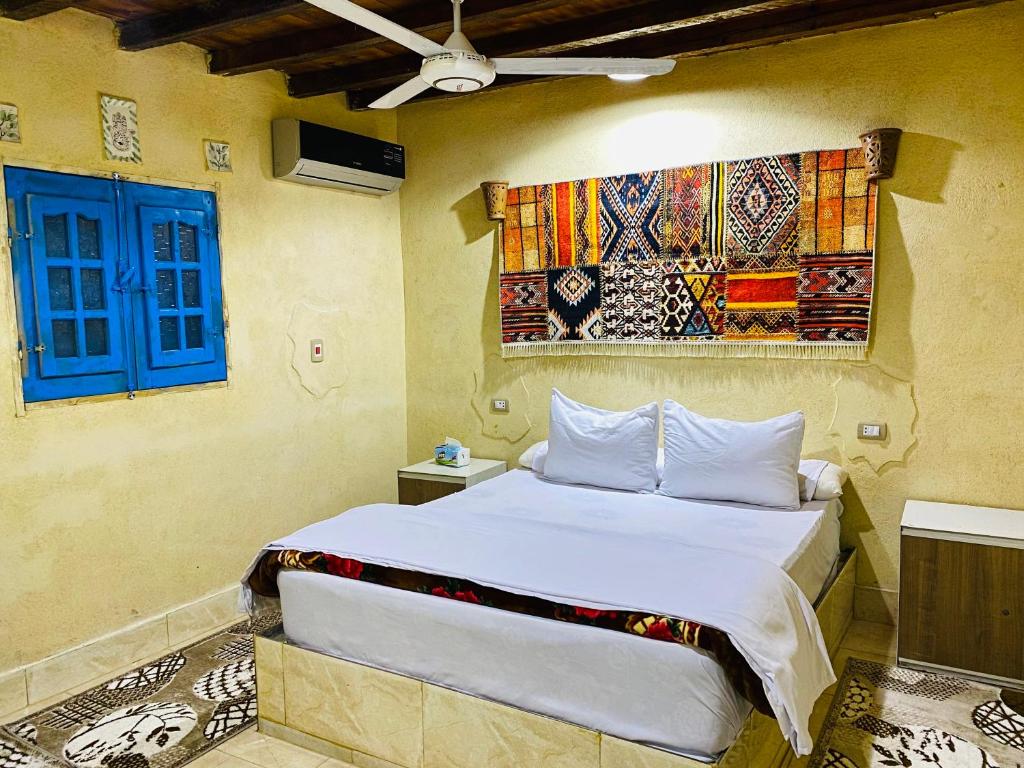 ‘Izbat an Nāmūsخزفستا Khazfista的一间卧室设有一张床和一个蓝色的窗户。