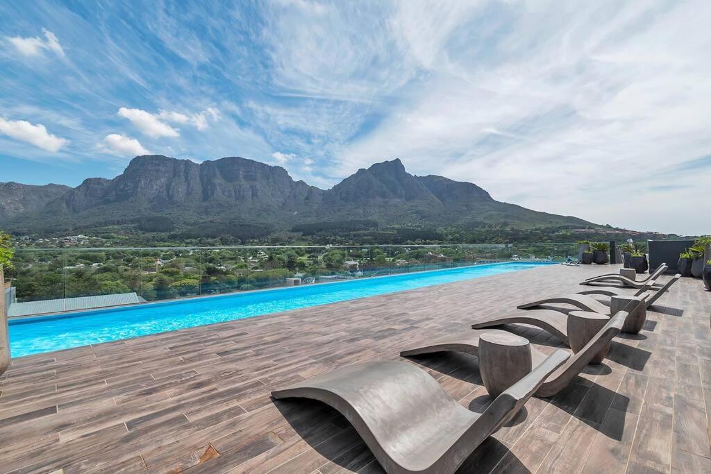 开普敦Rooftop with breathtaking views of Table Mountain.的山间庭院里摆放着一排躺椅