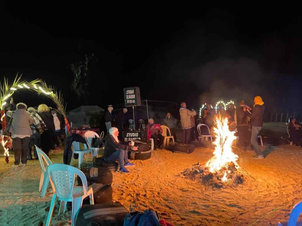 SabriaLuxury Camp Dunes Insolites Sabria的一群人坐在海滩上的火堆旁