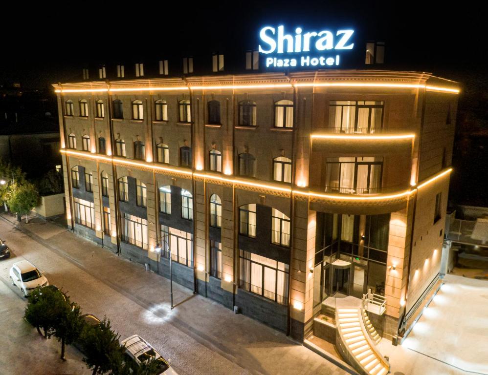 久姆里Shiraz Plaza Hotel & Spa的一座大建筑,上面有标志
