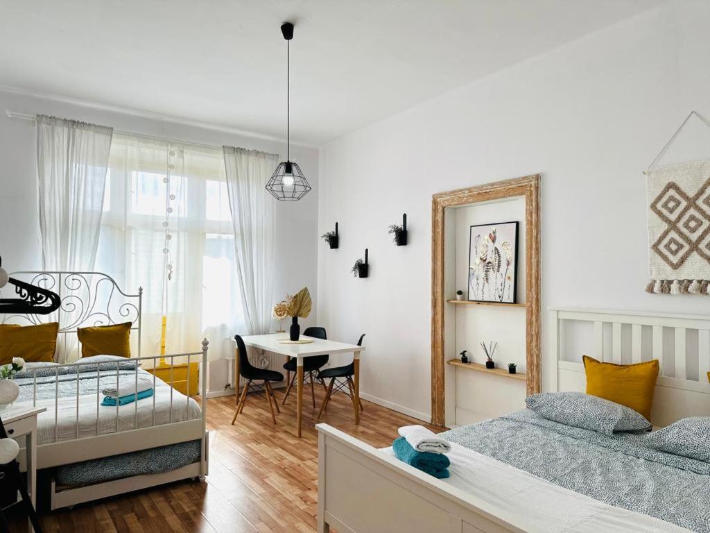 卡托维兹Cozy Apartments and Rooms Katowice的一间设有两张床和一张桌子的房间
