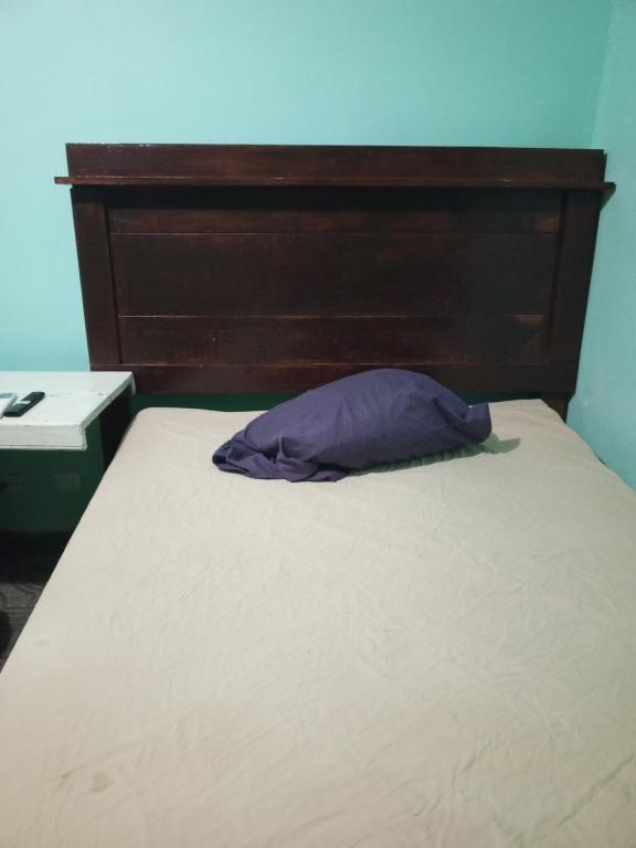 蒙特雷Recamara confortable en San Nicolás的一张带木制床头板和紫色枕头的床