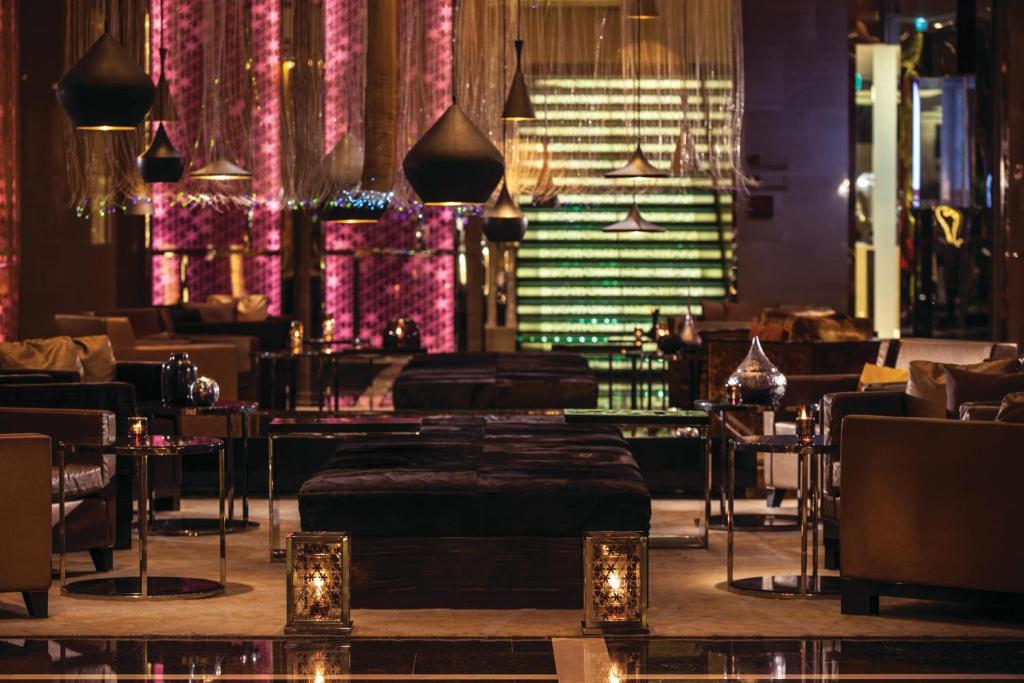 曼谷Renaissance Bangkok Ratchaprasong Hotel的一间带桌椅和灯光的餐厅
