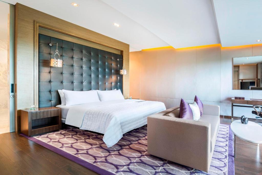 曼谷曼谷素万那普艾美高尔夫水疗度假酒店的酒店客房,配有床和沙发