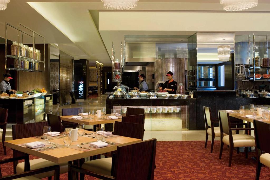 上海上海西藏大厦万怡酒店的餐厅设有木桌,厨房设有厨师