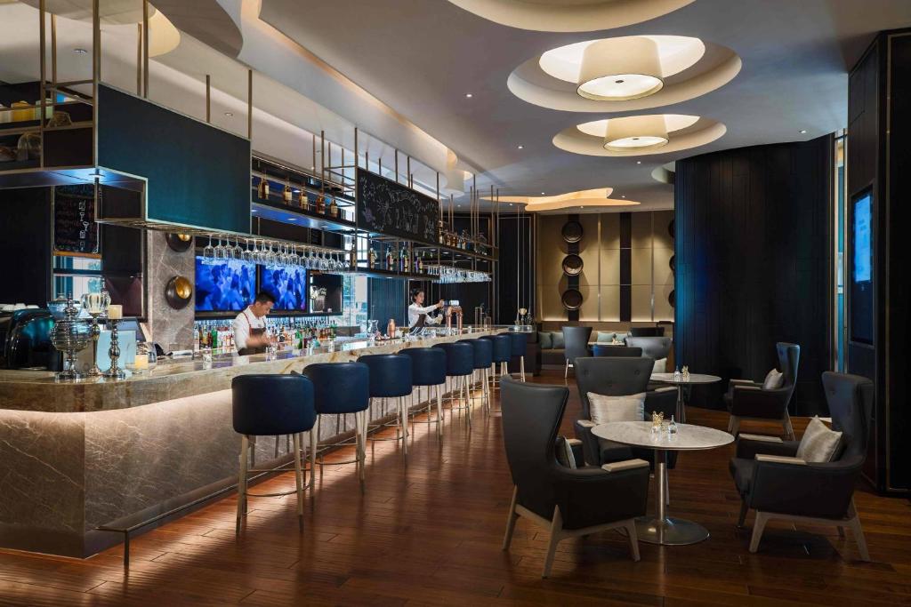 苏州苏州尼盛万丽酒店的餐厅设有酒吧,配有蓝色的桌椅
