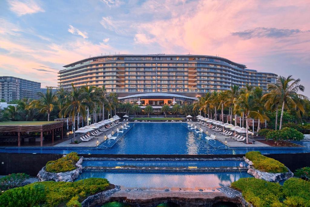 陵水海南蓝湾绿城威斯汀度假酒店（180°全海景客房）的大楼前设有游泳池的酒店