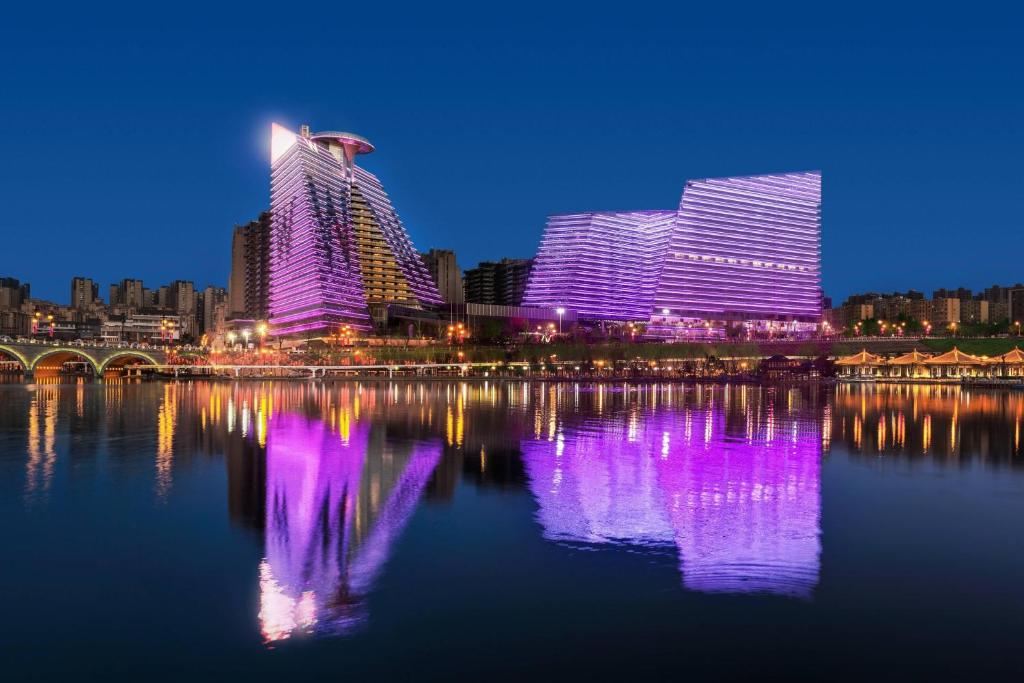 西安西安W酒店的城市天际线,夜晚在水面上闪烁紫色的灯光