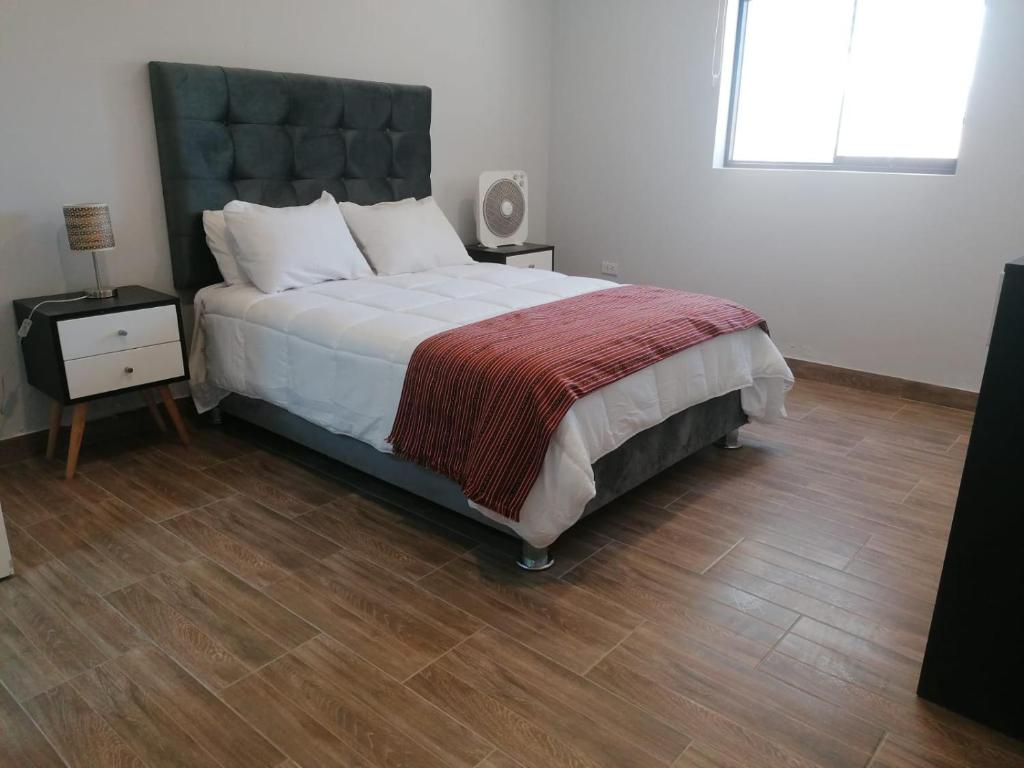伊察HOTEL SOL DE OCUCAJE的一间卧室设有一张大床,铺有木地板