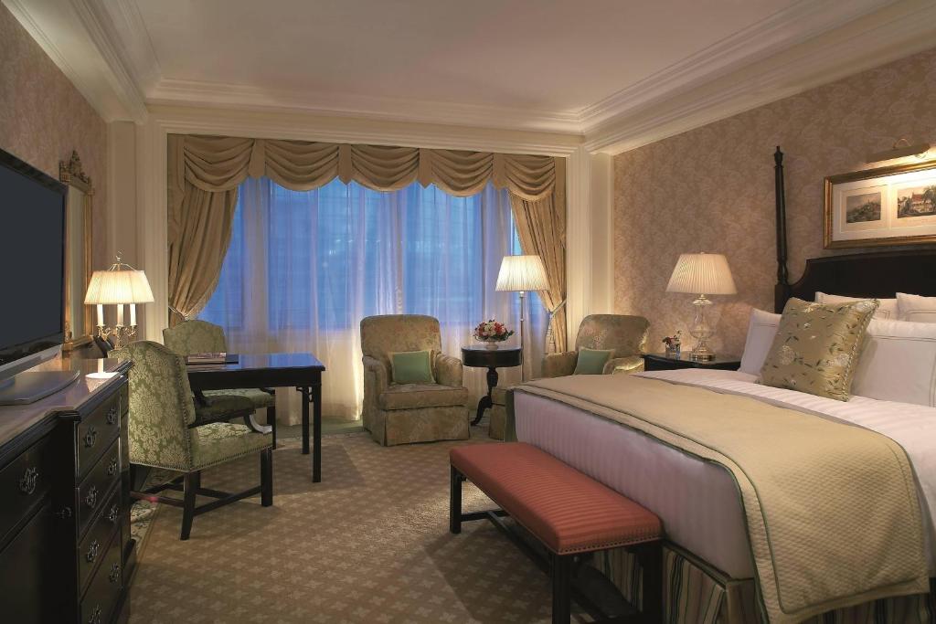 北京北京丽思卡尔顿酒店的酒店客房,配有一张床、一张桌子和椅子