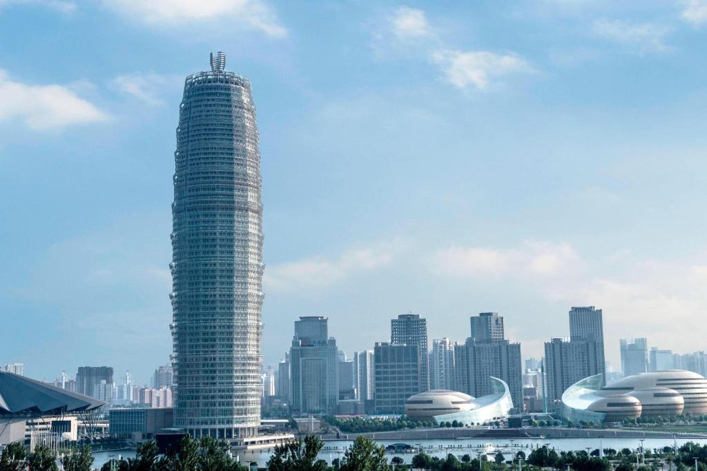 郑州郑州绿地JW万豪酒店的一座高大的建筑,以城市为背景