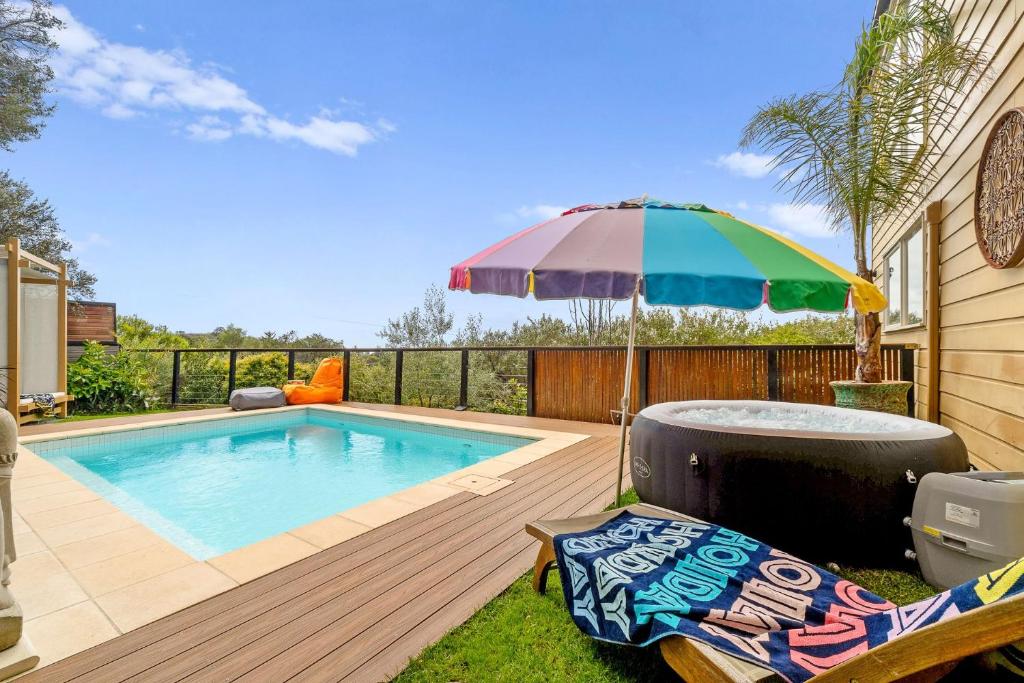 莱伊Ourania Luxury Villa with unforgettable sea views的一个带遮阳伞和椅子的游泳池