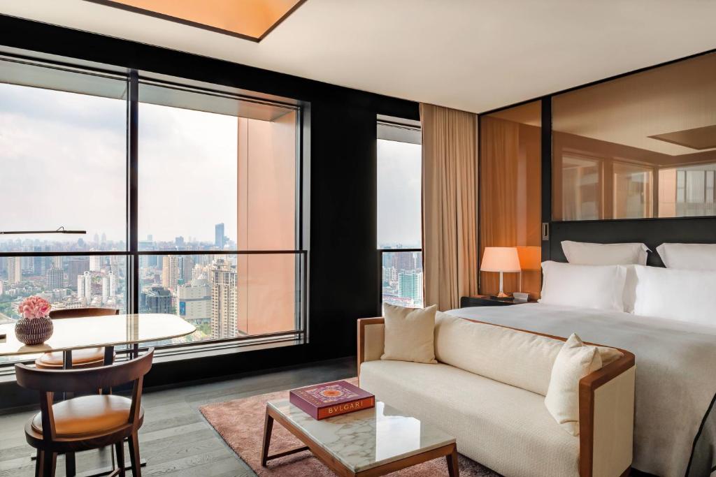 上海上海宝格丽酒店的一间卧室配有一张床、一张沙发和一张桌子