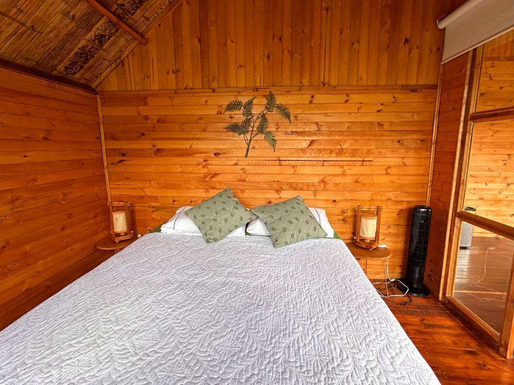拉维加Tropical House的卧室配有白色的木墙床