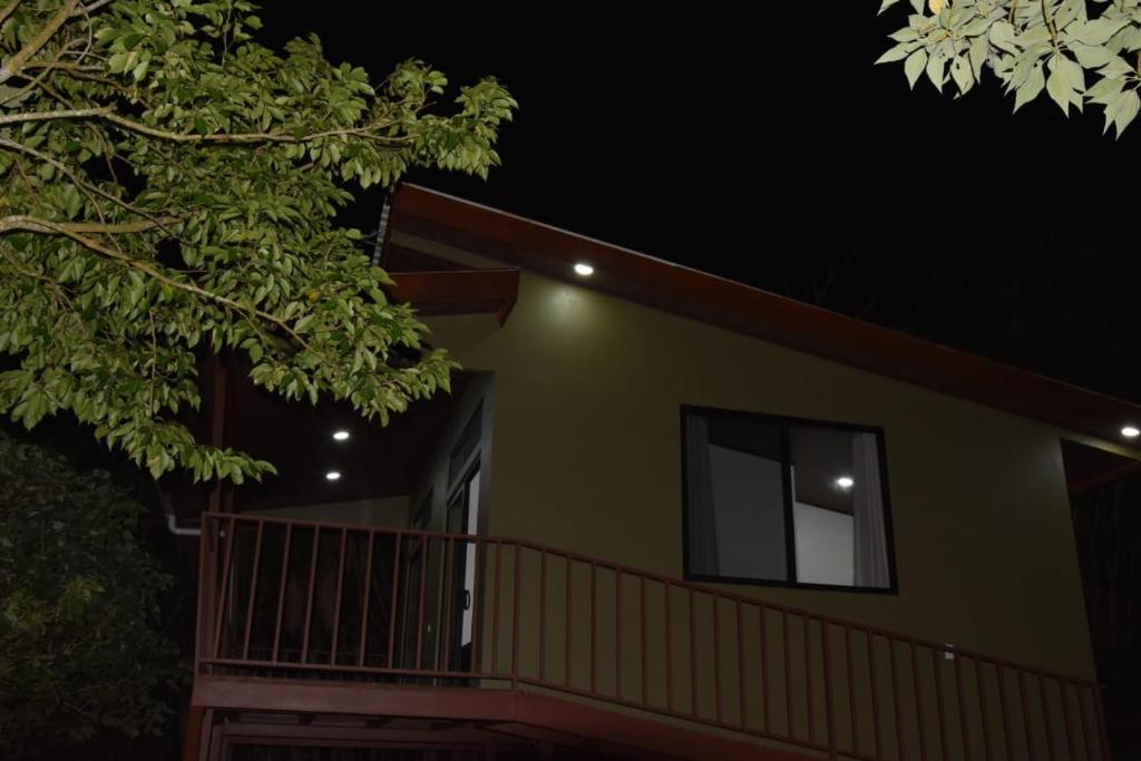 AbangaritosVilla Serena Monteverde的绿色房子,晚上设有阳台