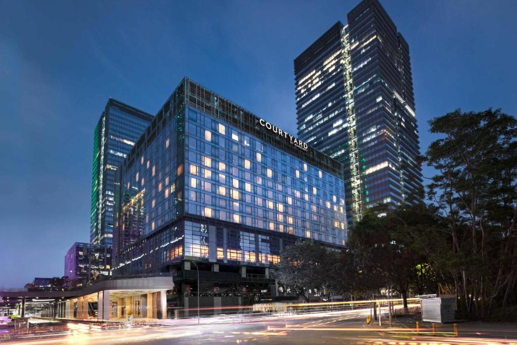 深圳深圳湾万怡酒店的一座高大的建筑,城市里灯火通明