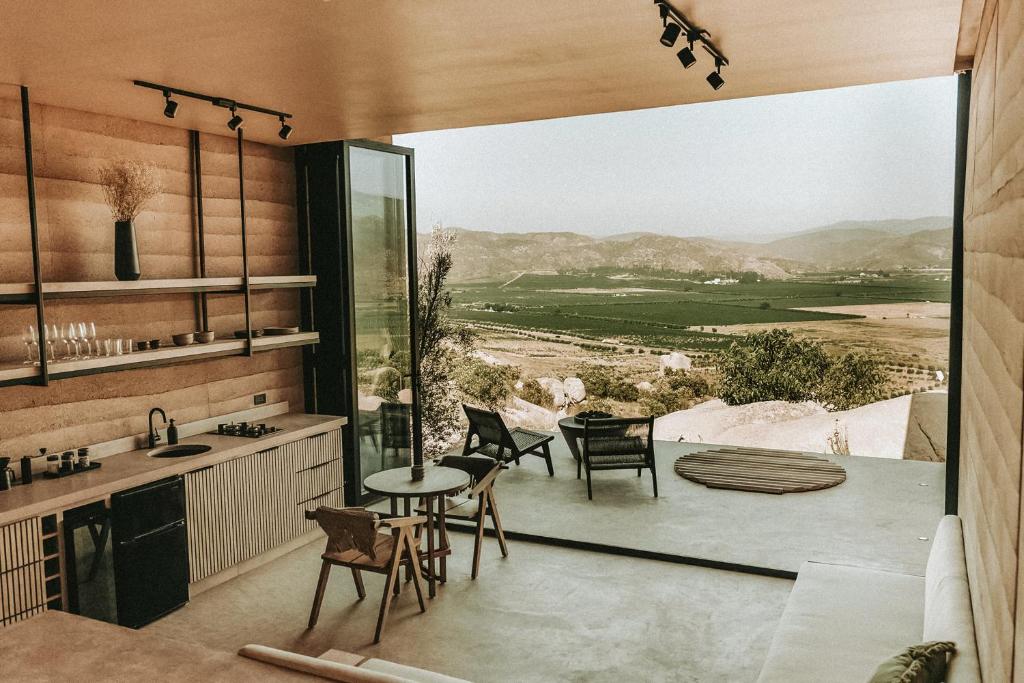 San Antonio de las MinasMIRA Earth Studios的一个带桌椅和大窗户的厨房