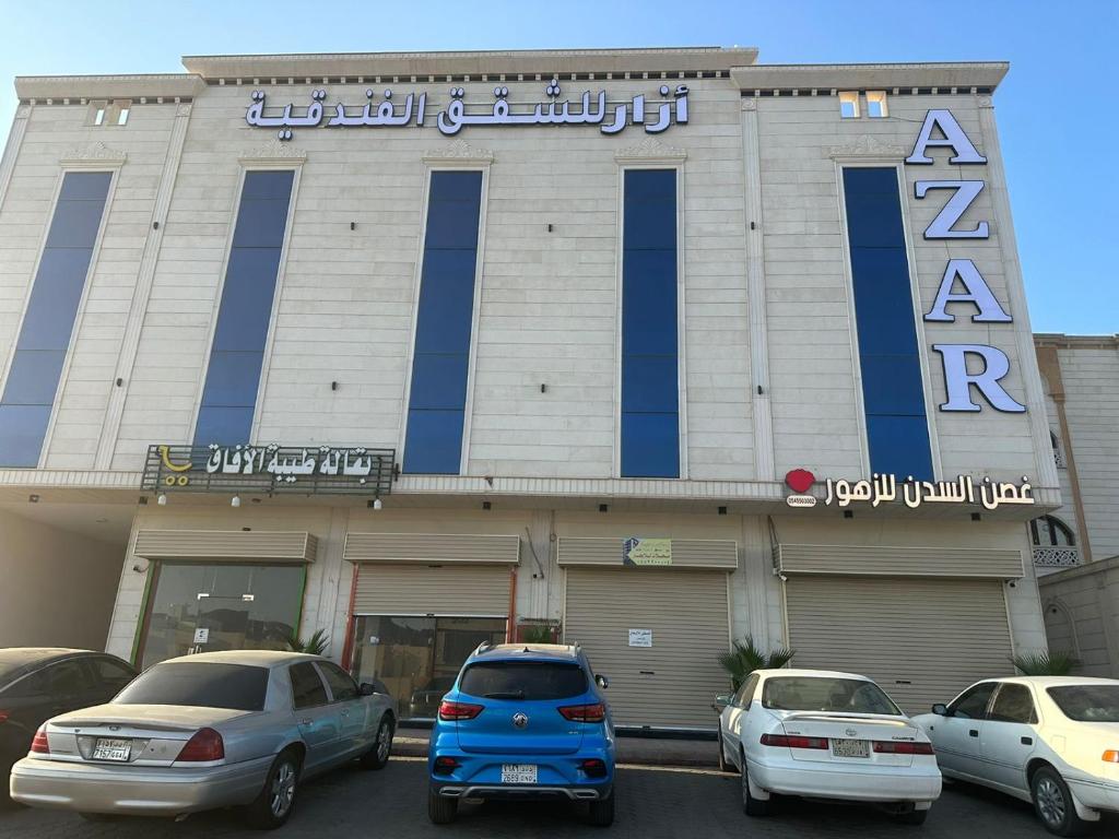 Abyār ‘Alīأزار للشقق الفندقية的前面有汽车停放的建筑