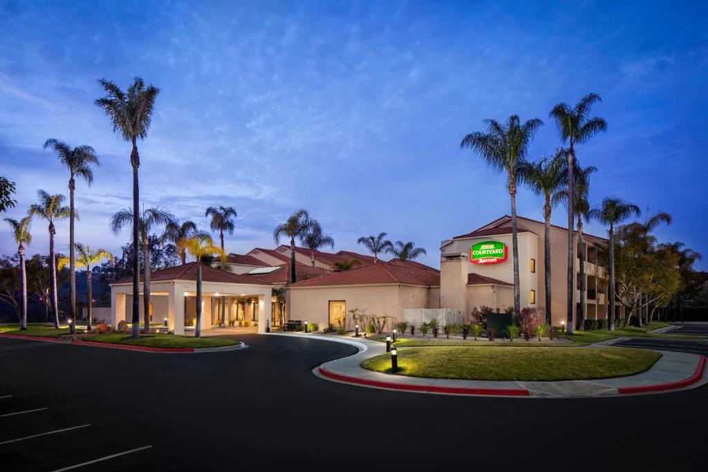 SorrentoCourtyard by Marriott San Diego Sorrento Valley的一座楼前有棕榈树的酒店