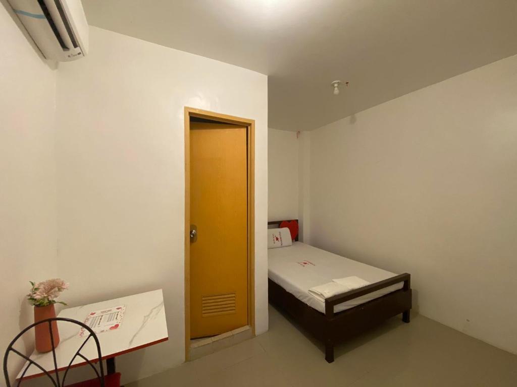 MaribagoWJV INN MARIBAG0的小房间设有一张小床和一扇黄色的门