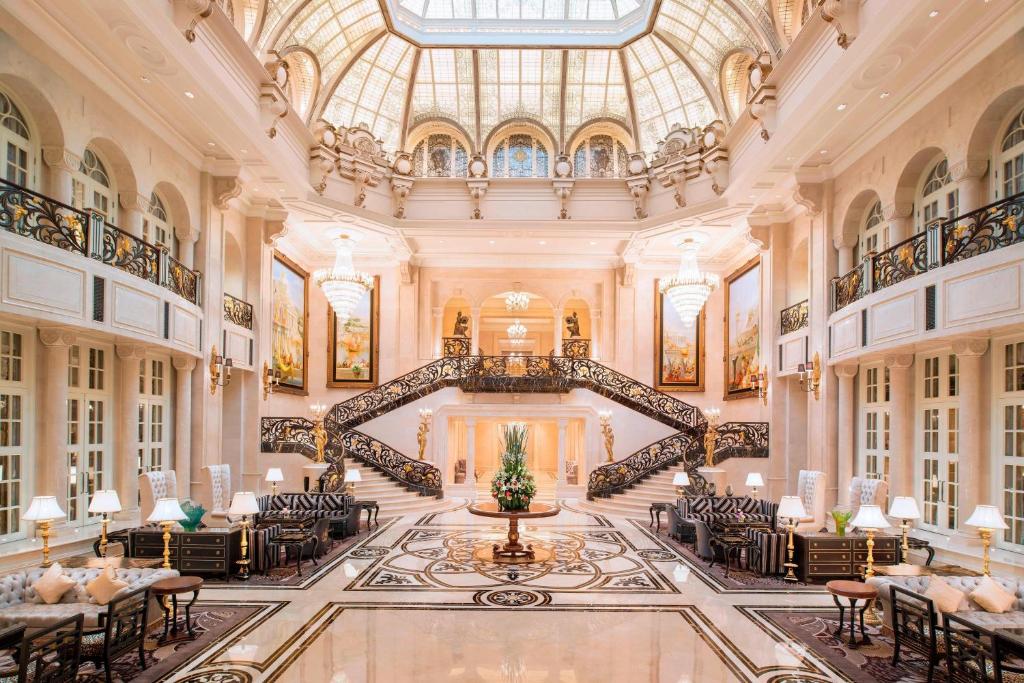大连大连一方城堡豪华精选酒店的酒店大堂设有螺旋楼梯和桌椅