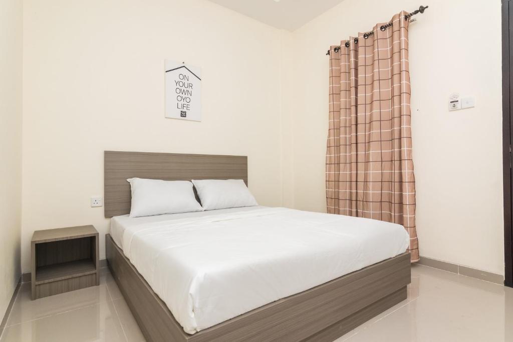 TanjungriauOYO Life 2735 Graha Nirwana的一间卧室配有一张带窗帘的大床