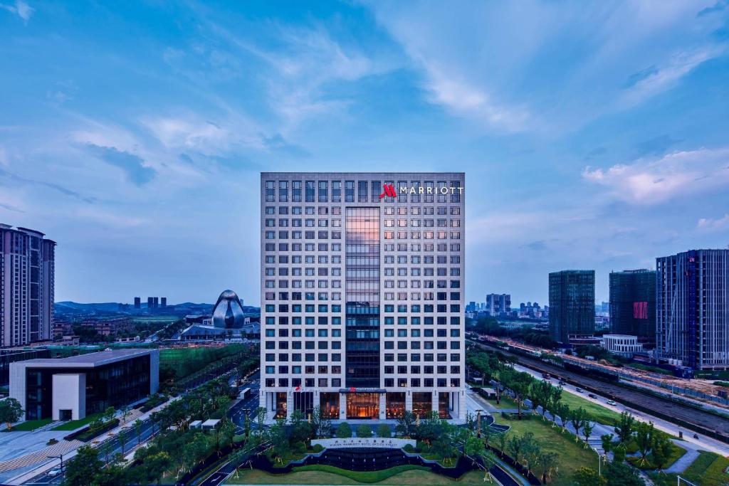 武汉武汉光谷万豪酒店的一座高大的白色建筑,上面有旗帜