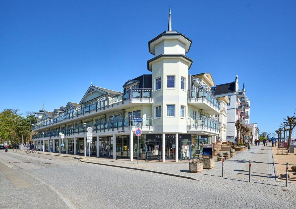 奥斯特西巴德钦诺维茨Strandpalais Luise von Preussen - Nebenhaus vom Strandhotel Preussenhof的街道上一座白色的建筑,有钟楼