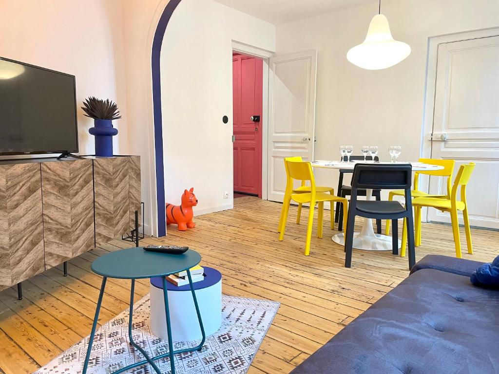 滨海贝尔克Appart 2 chambres HYPERCENTRE de Berck-Plage - WIFI的客厅配有桌子和黄色椅子
