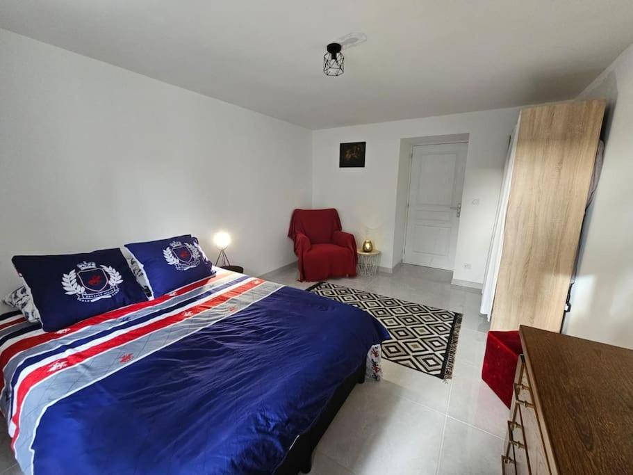 莫尔比耶Appartement T2 bis à morbier的一间卧室配有一张床和一张红色椅子