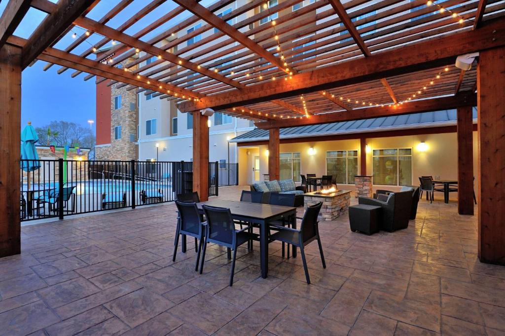 汤博尔Residence Inn by Marriott Houston Tomball的庭院设有木制凉亭和桌椅