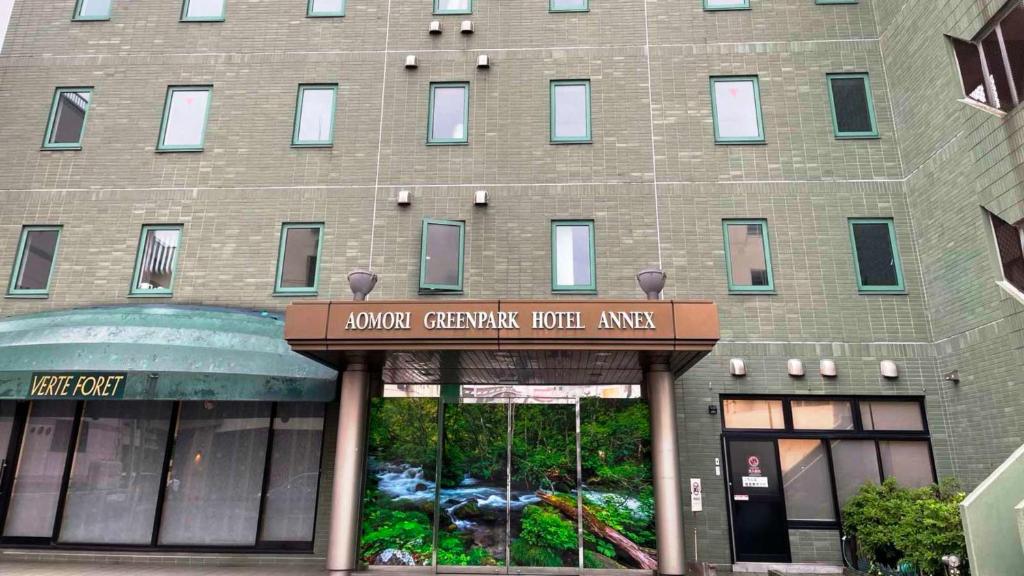 青森Aomori Green Park Hotel Annex的一座大型砖砌建筑,前面有标志