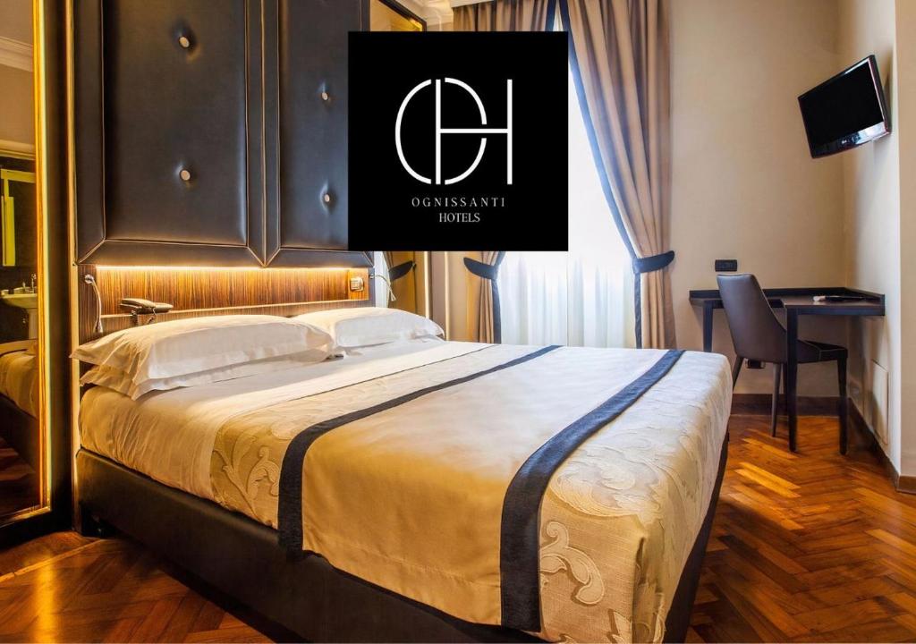 佛罗伦萨伦巴蒂酒店的酒店客房,配有一张带标志的床