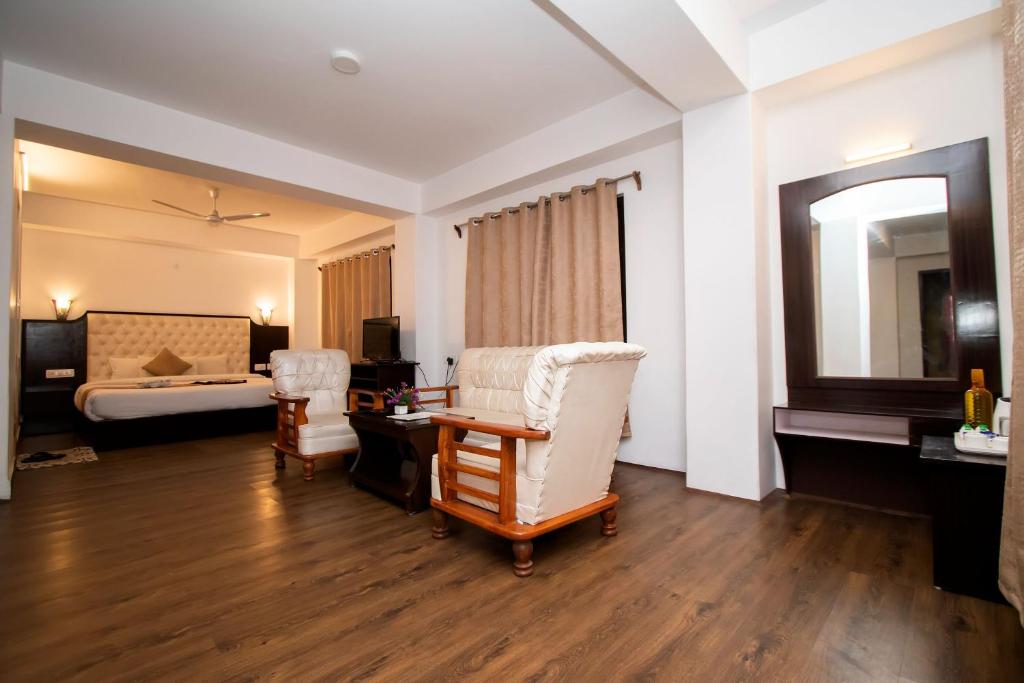 甘托克Tiara Regency Gangtok的酒店客房,配有一张床、一张桌子和椅子