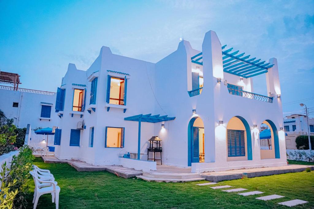 Qaryat at Ta‘mīr as Siyāḩīyah4 bedrooms villa with private pool in Tunis village faiuym的前面有草坪的白色房子