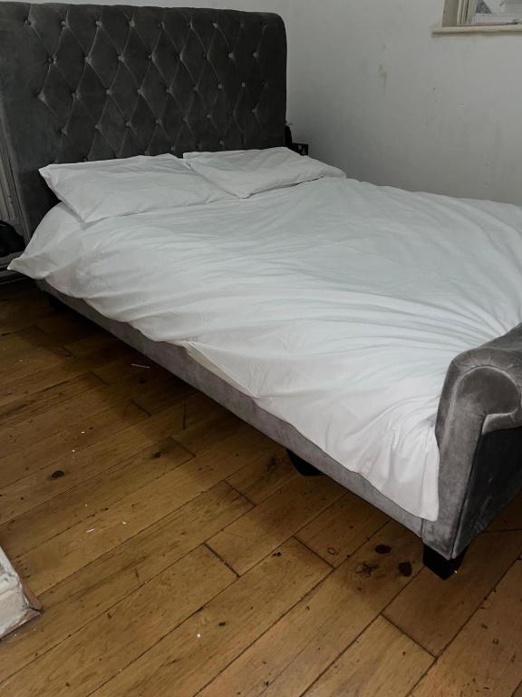 伦敦Come stay x的一张带金属床头板和白色床单的床