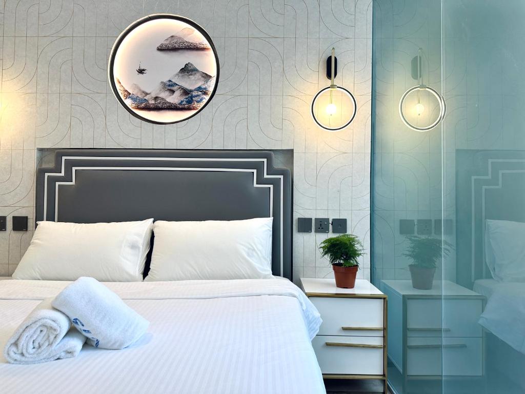 新加坡Kam Leng Hotel的卧室配有白色的床和镜子