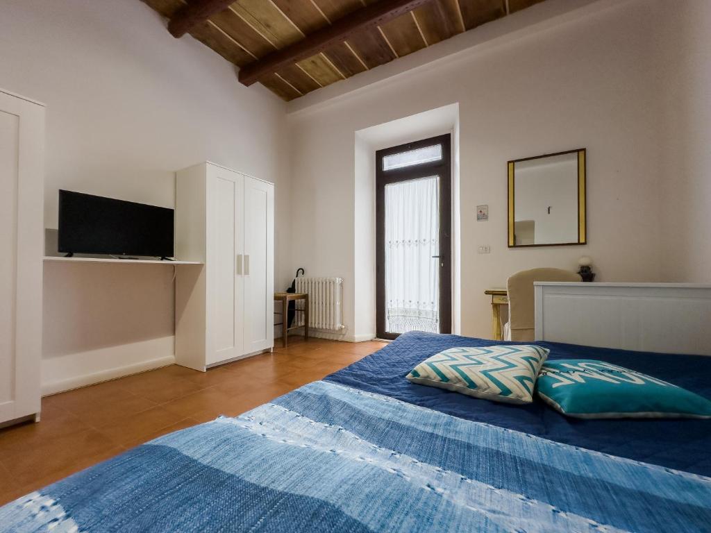 法尔科纳拉·玛里提马Host4All casa vacanze的一间卧室配有一张带蓝色床单的床和电视。