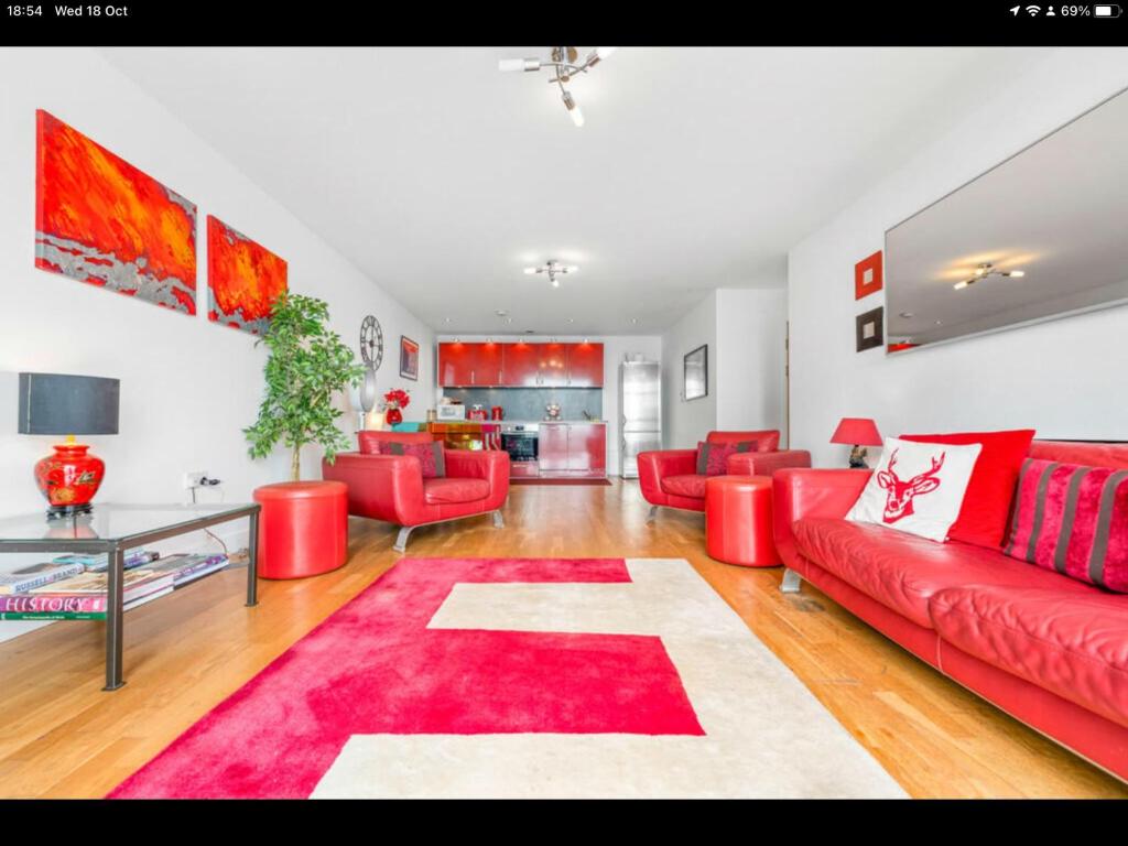 卡迪夫Stunning Spacious City Apartment with free parking的客厅配有红色家具和红色地毯。