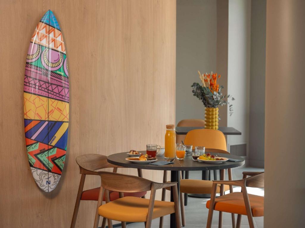 丰特奈苏布瓦Novotel Paris Val de Fontenay的用餐室配有桌子和冲浪板。