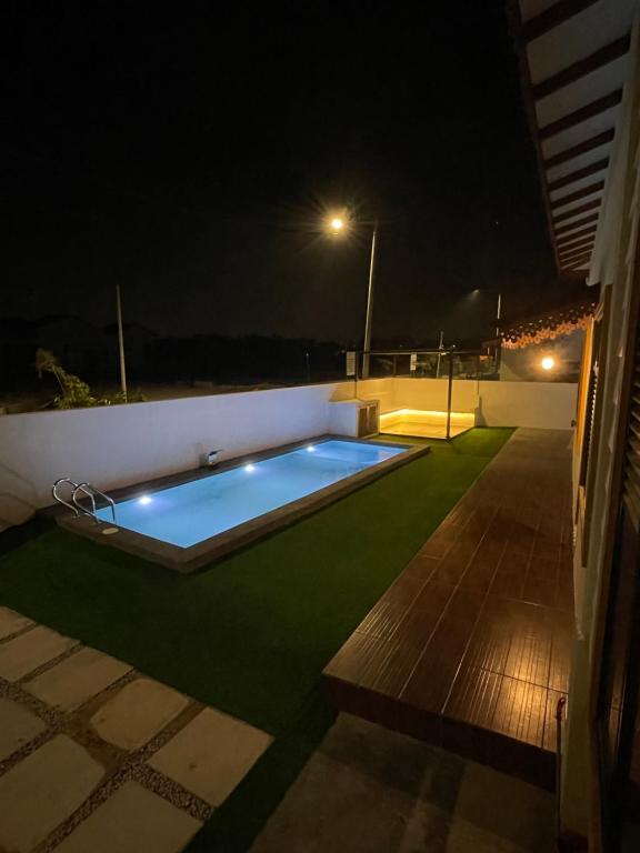 Kampong Bukit KatilTraditional Melaka Homestay with Private Pool的夜间在院子中间的游泳池