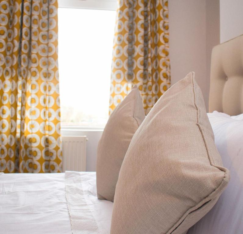 达灵顿Paradise House Darlington的一张带两个枕头的床和窗户